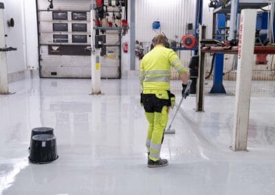 Remontoija tasoittaa epoksimassaa lattiaan.